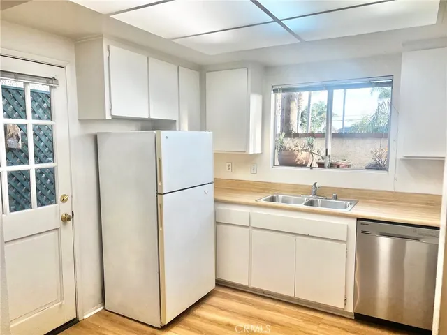a kitchen with white cabinets and white appliances