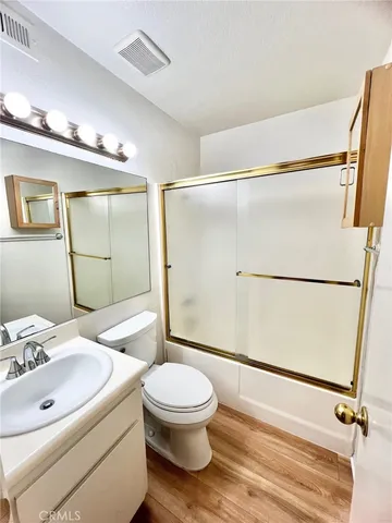 a bathroom with a sink a toilet a mirror and shower