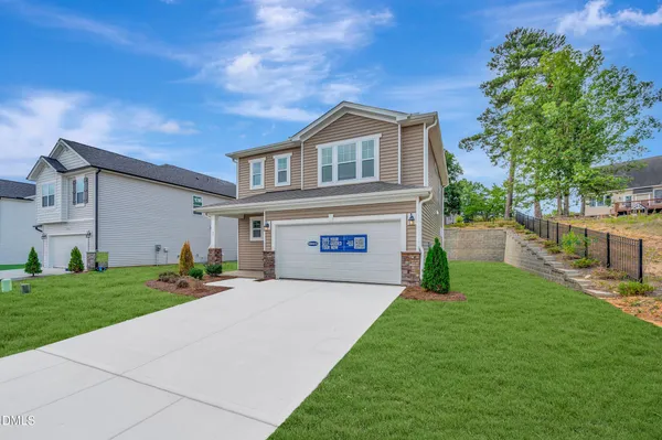 a front view of a house with a yard and garage