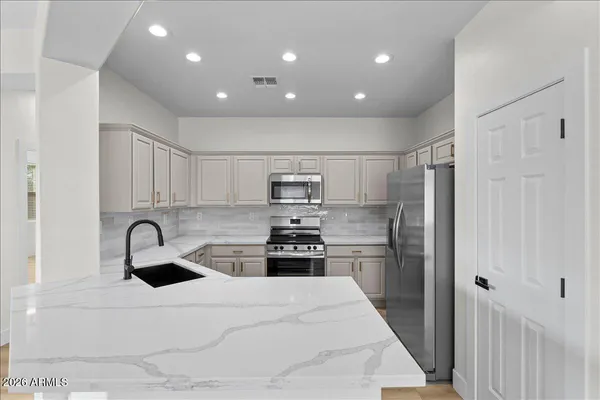 a kitchen with kitchen island stainless steel appliances sink refrigerator and stove