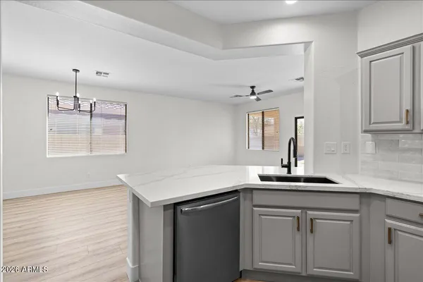 a kitchen with a sink dishwasher and white cabinets