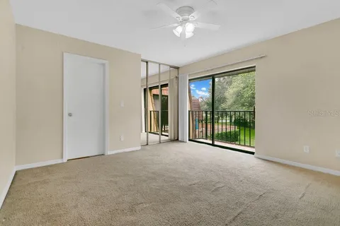 a view of an empty room with closet and a window