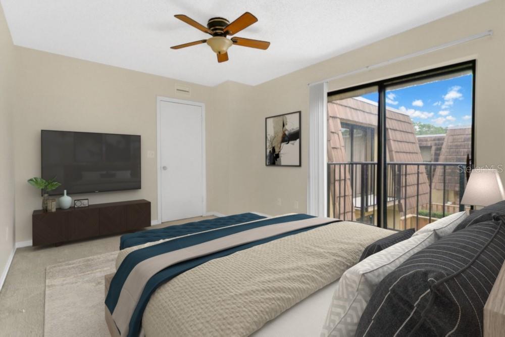 5286 Willow Court, Unit 505 Orlando, FL 32811 - Photo 20 of 33 a bedroom with a large bed and a flat tv screen