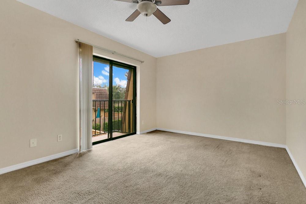 5286 Willow Court, Unit 505 Orlando, FL 32811 - Photo 22 of 33 an empty room with a ceiling fan and carpet