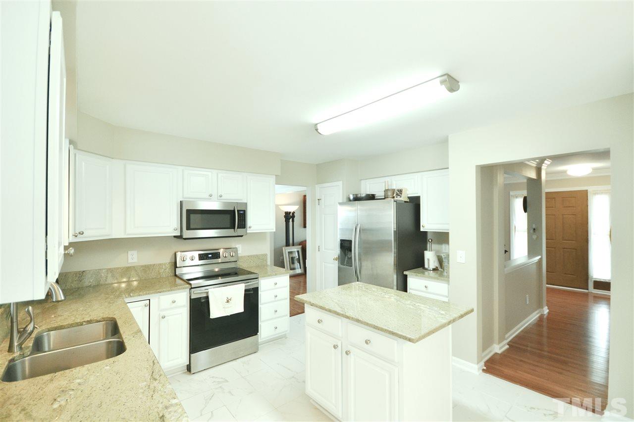 2341 Kendricks Court Raleigh, NC 27613 - Photo 11 of 29 a kitchen with stainless steel appliances kitchen island granite countertop a refrigerator and a stove top oven