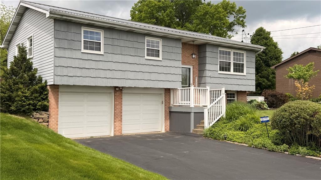 1403 2nd Avenue Beaver, PA 15009 - Photo 2 of 17 a front view of a house with a garden and garage