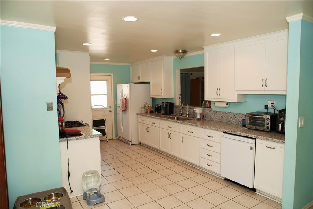 6431 Cathay Circle Buena Park, CA 90620 - Photo 24 of 65 a kitchen with granite countertop cabinets a sink a window and stainless steel appliances