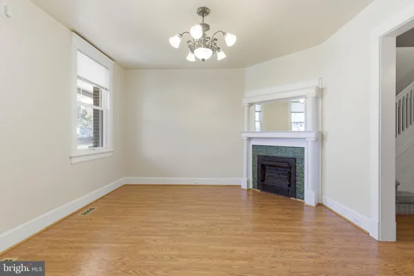 a view of empty room with fireplace and wooden floor