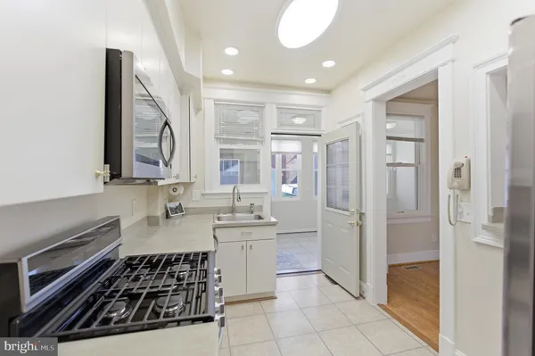 a kitchen with white cabinets and stainless steel appliances