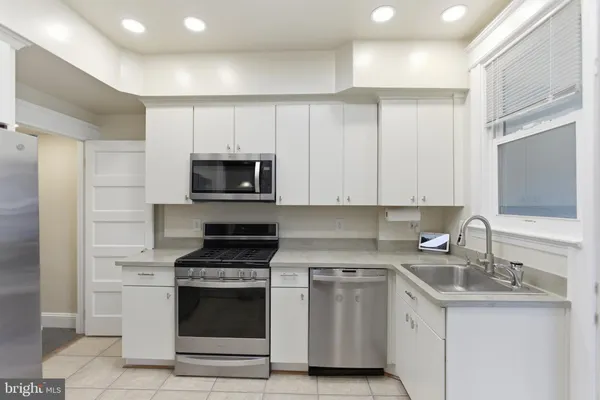 a view of a hallway with wooden floor and a bathroom