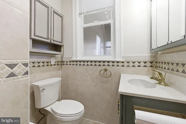 a bathroom with a toilet a sink and a mirror