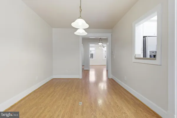 a view of a room with wooden floor and a ceiling fan