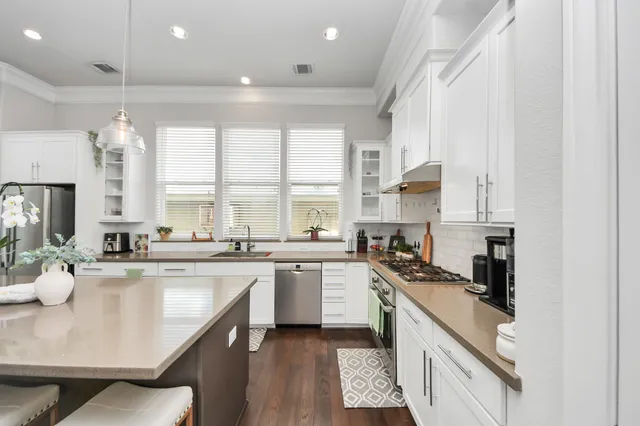 a kitchen with a sink stove cabinets and refrigerator