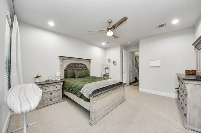 a spacious bedroom with a bed and a chandelier
