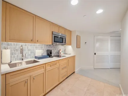 a kitchen with granite countertop white cabinets and stainless steel appliances
