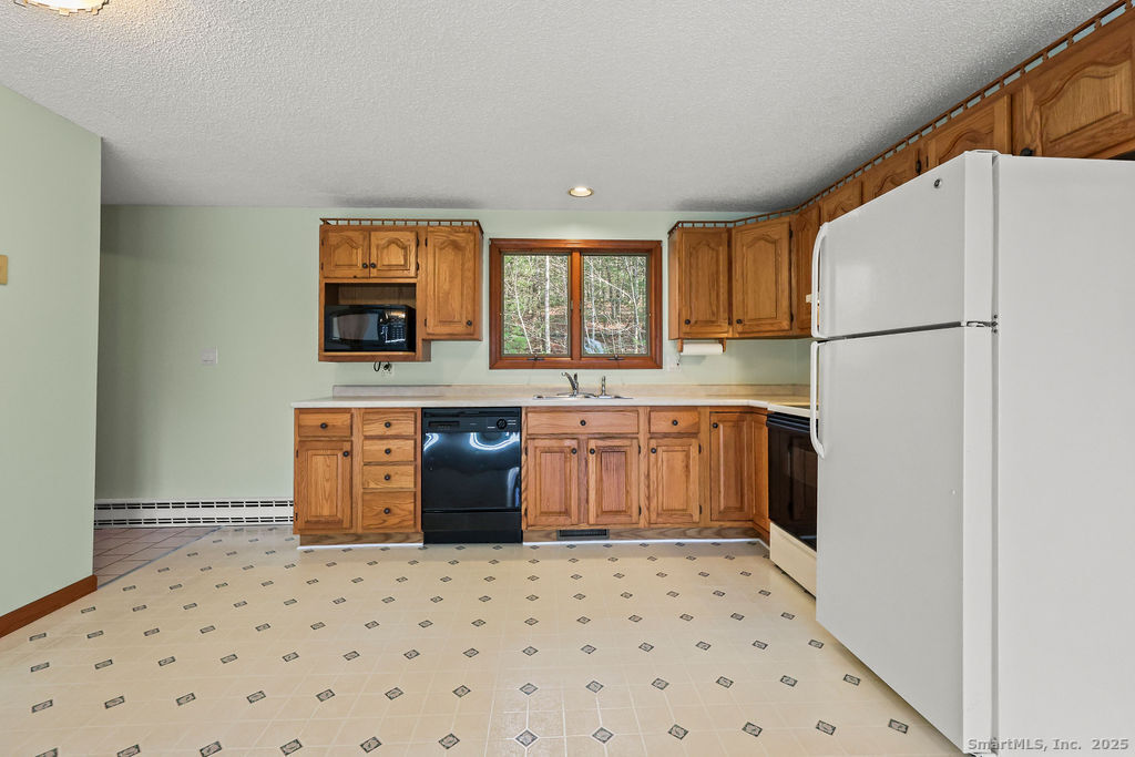 15 Deepwood Road Stafford, CT 06076 - Photo 14 of 30 a kitchen with a sink a refrigerator and a stove top oven
