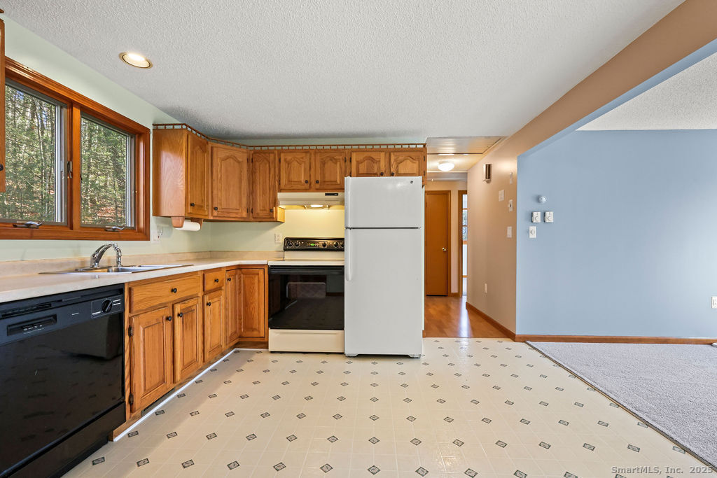 15 Deepwood Road Stafford, CT 06076 - Photo 15 of 30 a kitchen with a refrigerator sink and cabinets