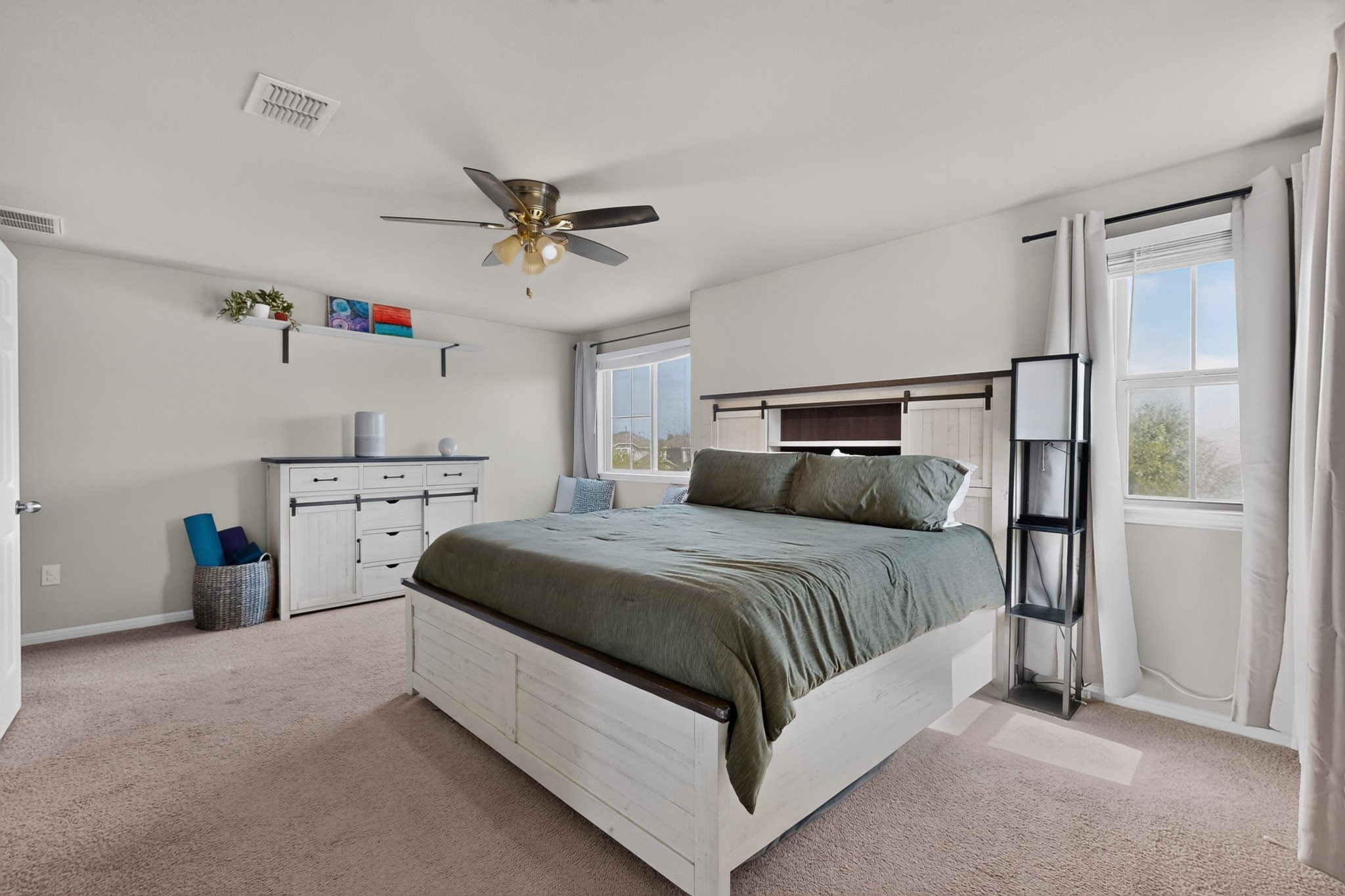 132 Wapiti Road Buda, TX 78610 - Photo 9 of 31 Natural light streams into this generously proportioned bedroom, creating a peaceful and inviting atmosphere.
