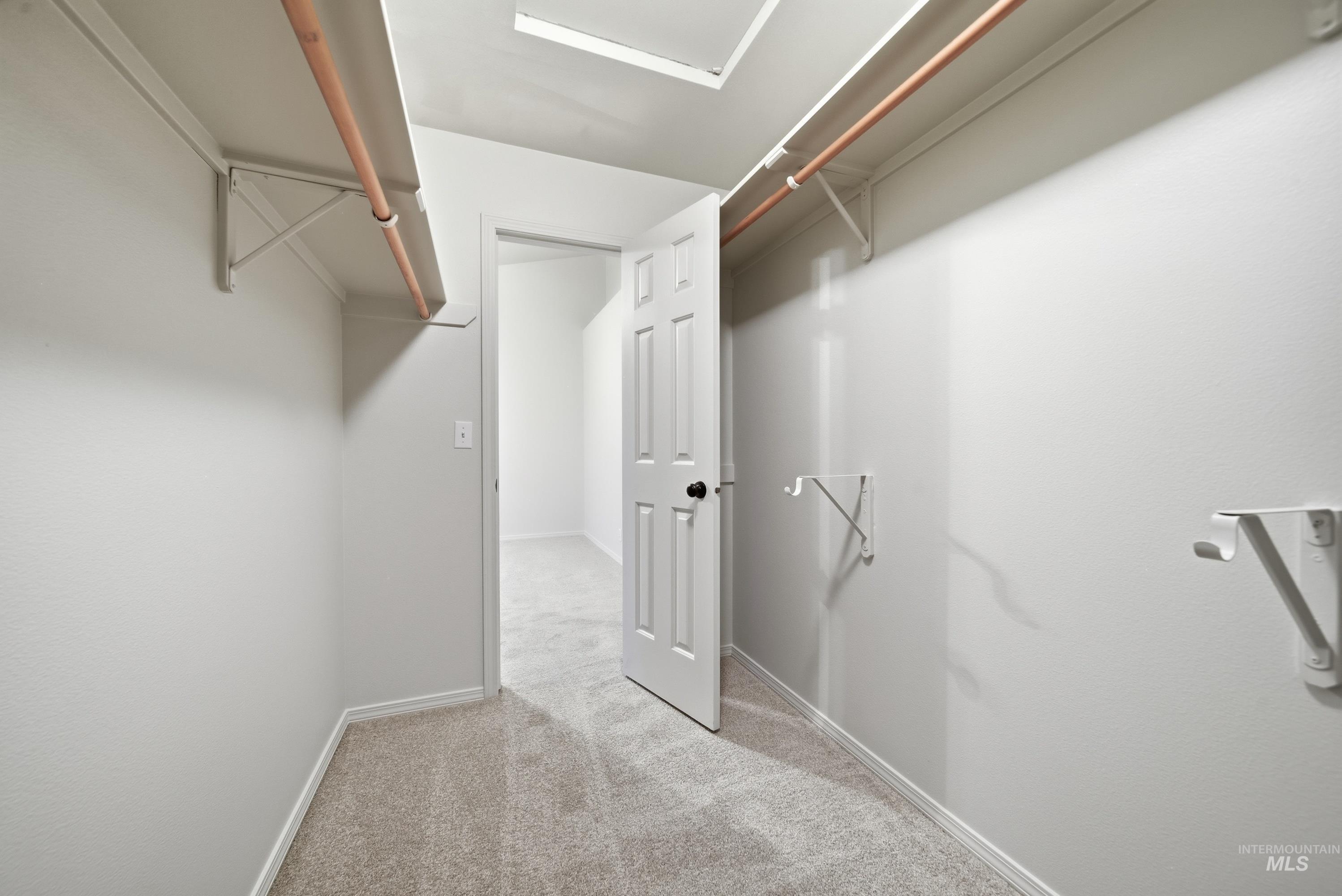 919 East Hawk Street Meridian, ID 83646 - Photo 23 of 31 Walk-in closet featuring light-colored carpeting, white shelving, and hanging rods