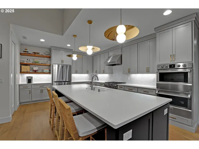 a kitchen with a counter space a sink stainless steel appliances and cabinets