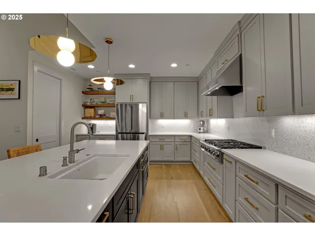 a kitchen with kitchen island granite countertop a sink stainless steel appliances and cabinets
