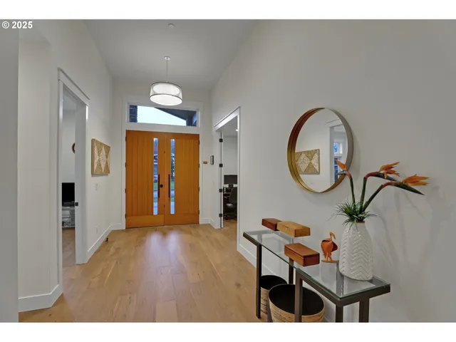 a living room with furniture a mirror and wooden floor