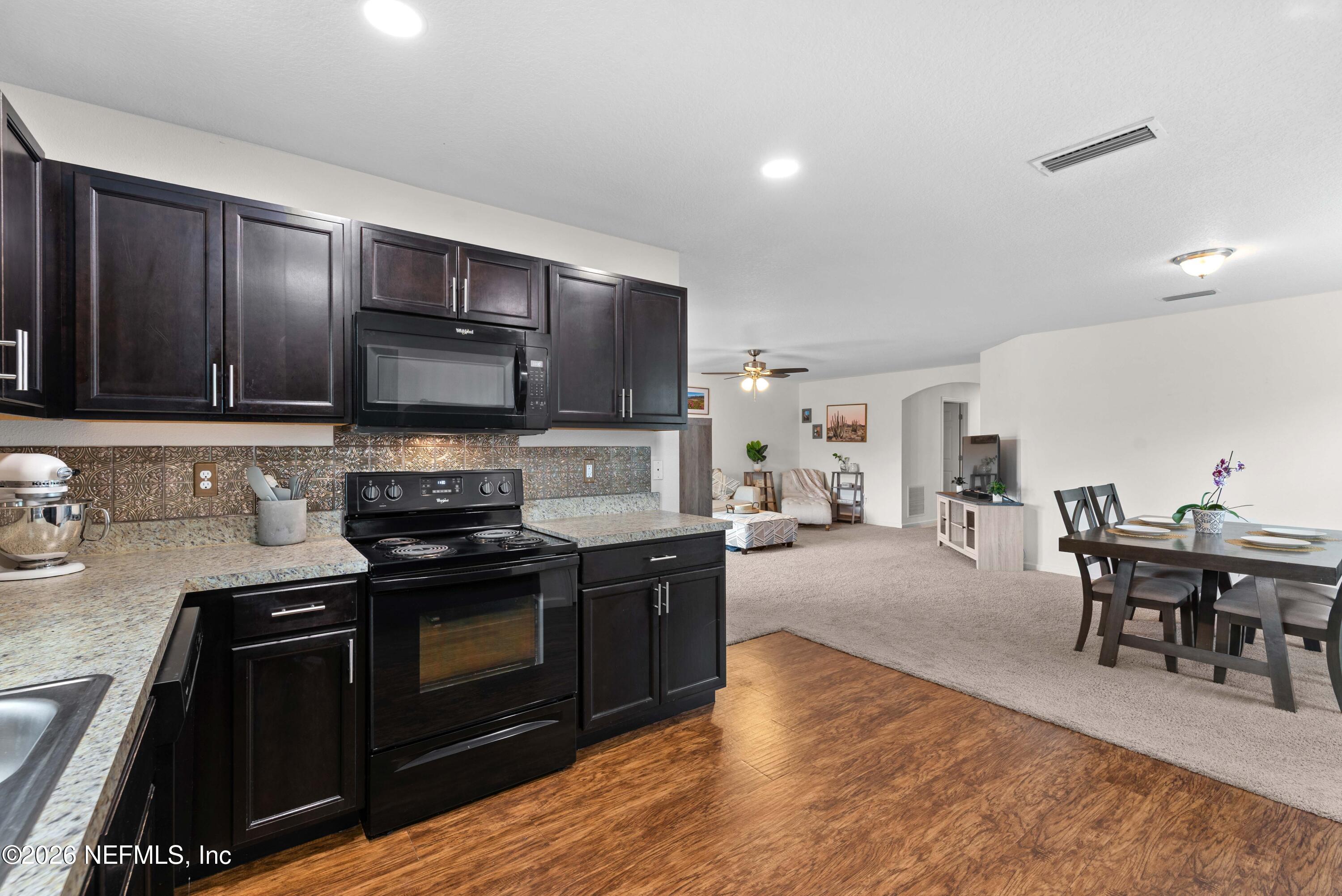 6178 Daylilly Road Macclenny, FL 32063 - Photo 12 of 29 a kitchen with stainless steel appliances granite countertop a stove and a sink