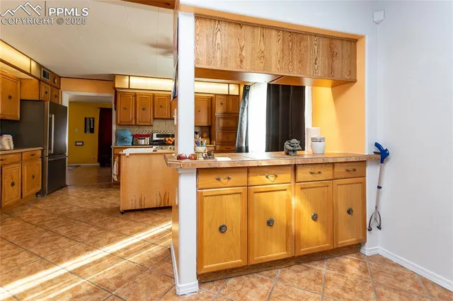 a view of a kitchen with wooden floor and stainless steel appliances