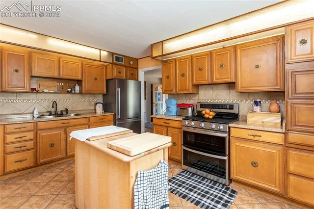 a kitchen with stainless steel appliances a refrigerator sink and cabinets