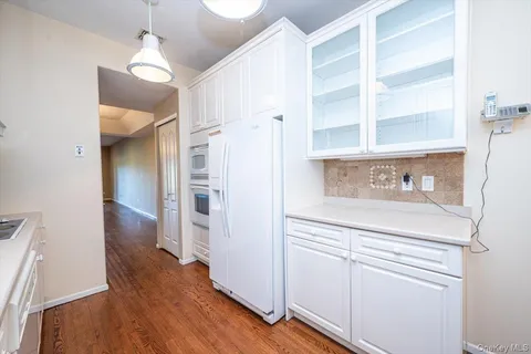 a kitchen with wooden floor and cabinets