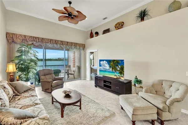 a living room with furniture a ceiling fan and a large window
