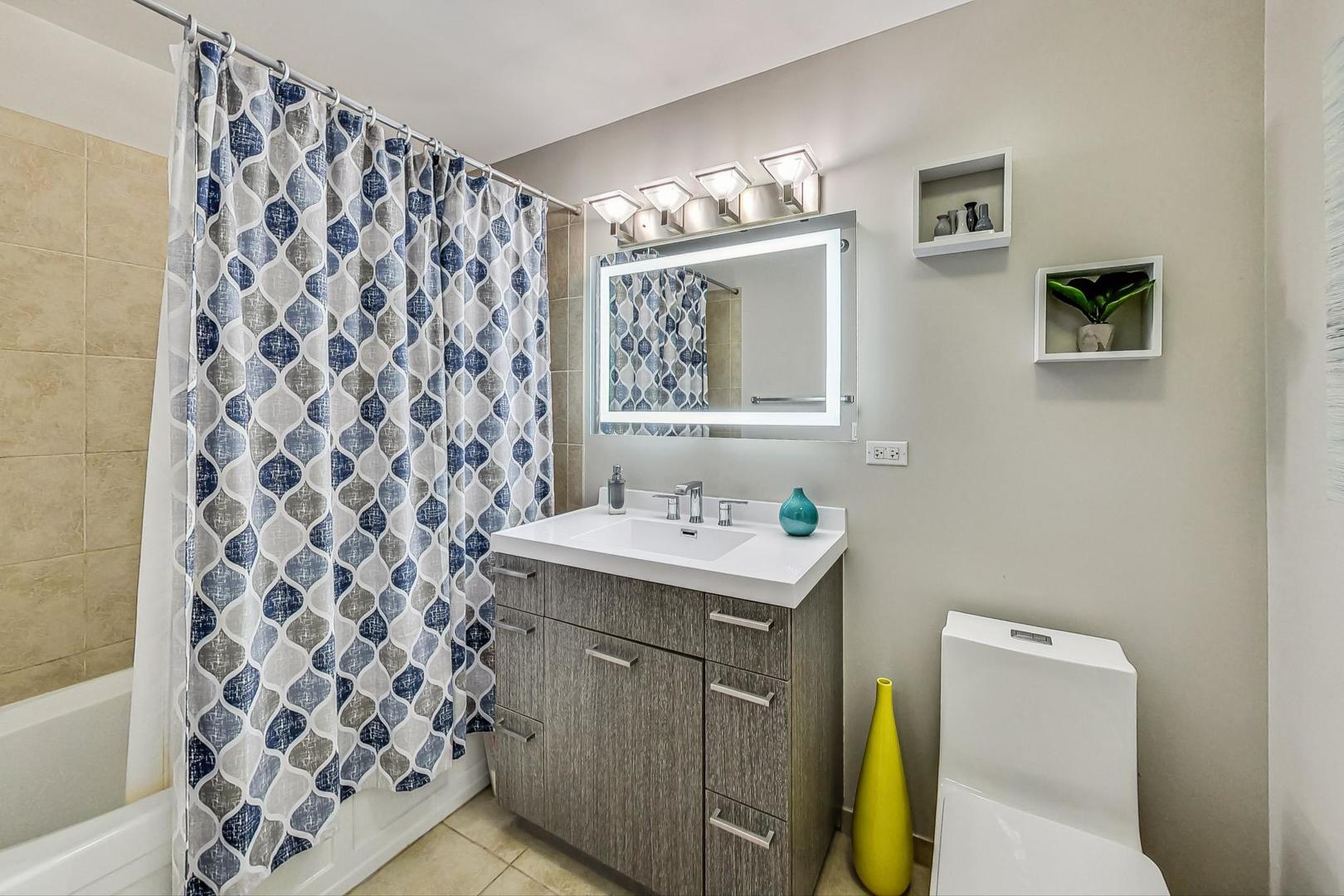 235 West Van Buren Street, Unit 1517 Chicago, IL 60607 - Photo 8 of 15 a bathroom with a sink and a mirror