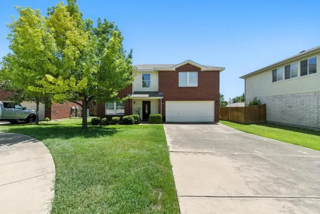 a front view of a house with a yard and a garage