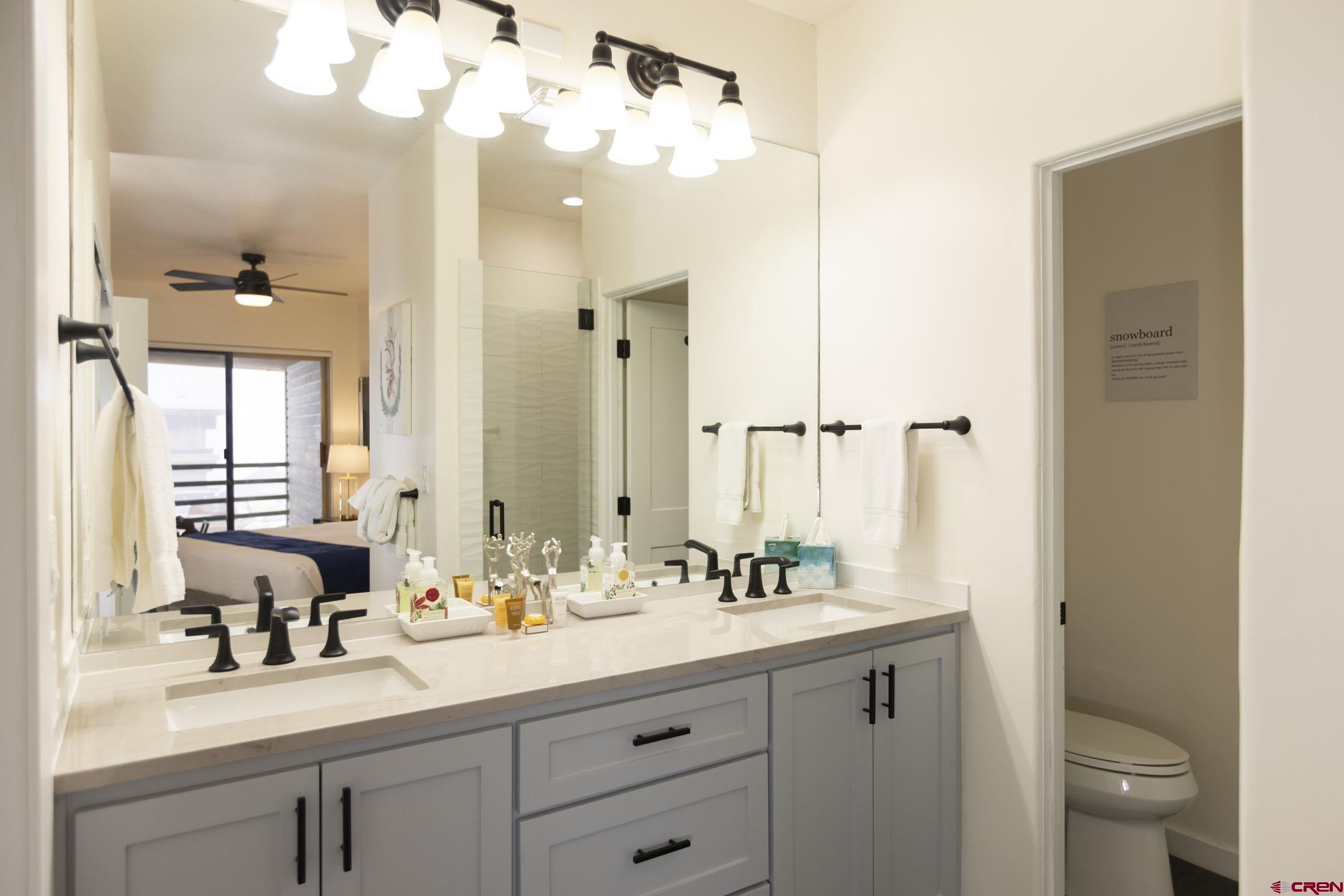 117 Needles Way, Unit 720 Durango, CO 81301 - Photo 11 of 33 a bathroom with a double vanity sink mirror and toilet
