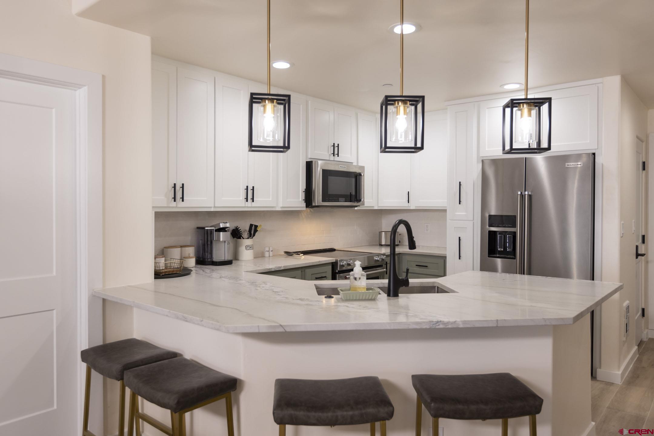 117 Needles Way, Unit 720 Durango, CO 81301 - Photo 4 of 33 a kitchen with stainless steel appliances granite countertop a sink and a refrigerator