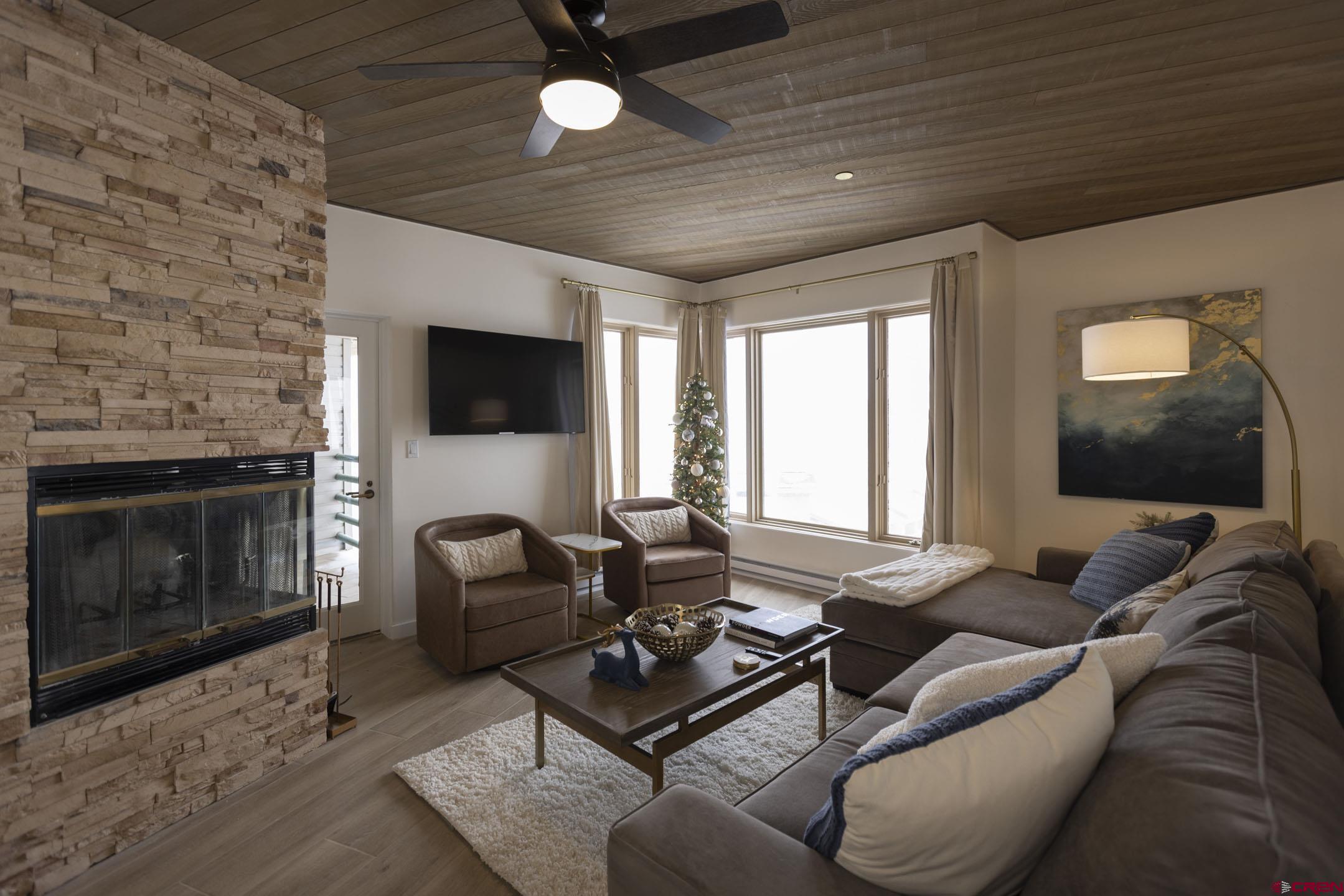 117 Needles Way, Unit 720 Durango, CO 81301 - Photo 7 of 33 a living room with furniture a fireplace and a flat screen tv