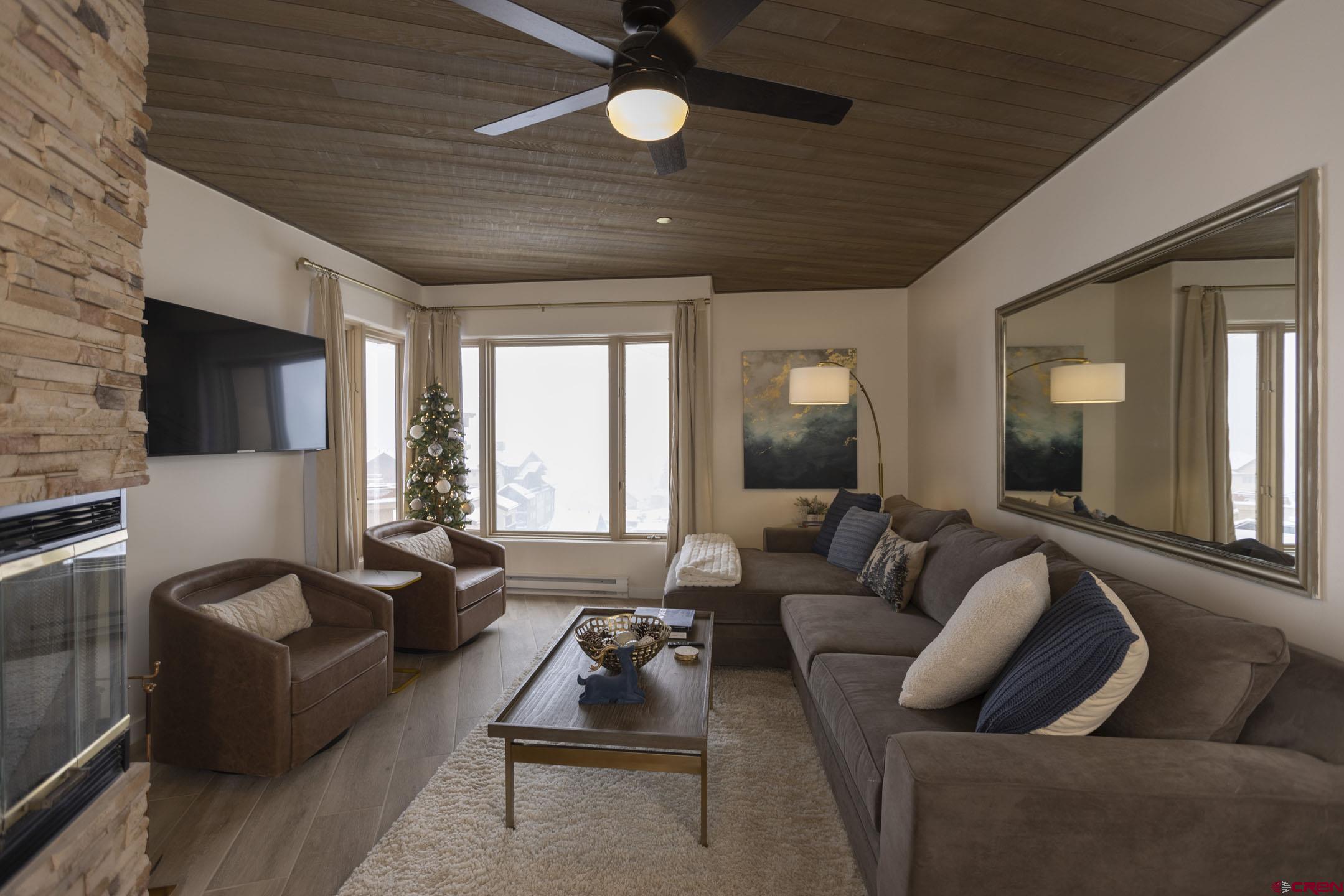 117 Needles Way, Unit 720 Durango, CO 81301 - Photo 8 of 33 a living room with furniture a fireplace and a flat screen tv