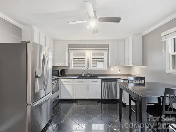 a kitchen with a refrigerator and a stove top oven