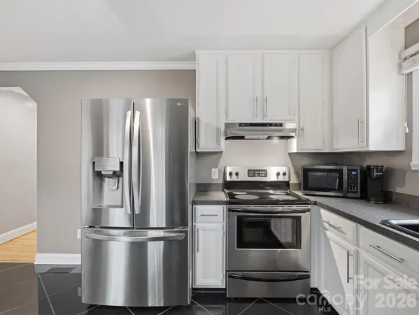 a metallic refrigerator freezer sitting inside of a kitchen