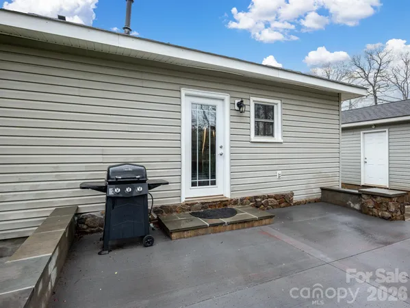a backyard of a house with barbeque oven and seating space