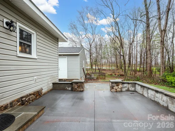 a view of a patio with table and chairs and wooden fence