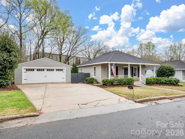 a view of a white house with a large tree