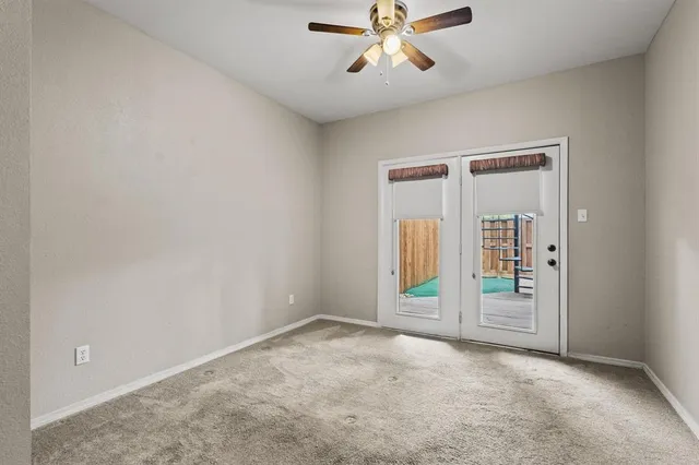 an empty room with ceiling fan and shower
