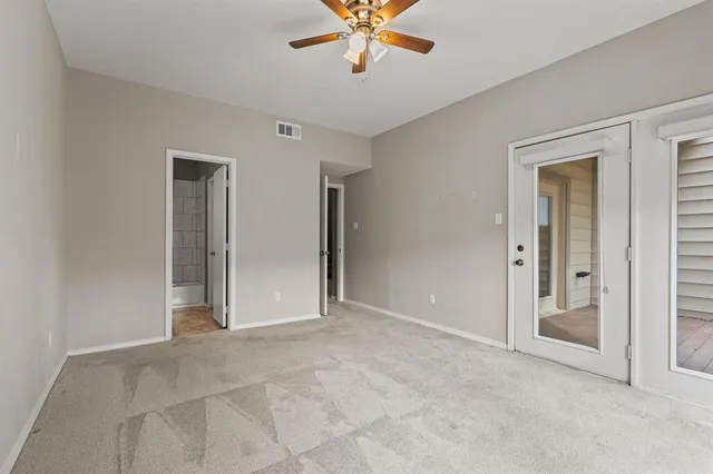 an empty room with closet and windows