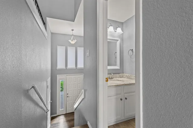 a bathroom with a granite countertop sink a toilet a window and vanity