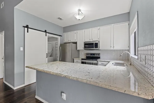 a kitchen with refrigerator and microwave