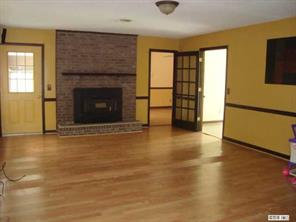 125 Bobwhite Road Cheraw, SC 29520 - Photo 3 of 6 an empty room with wooden floor and fireplace