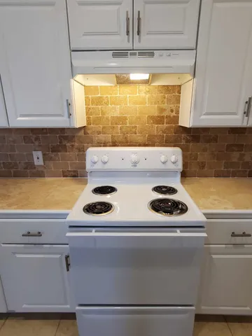 a kitchen with a stove and a white cabinet