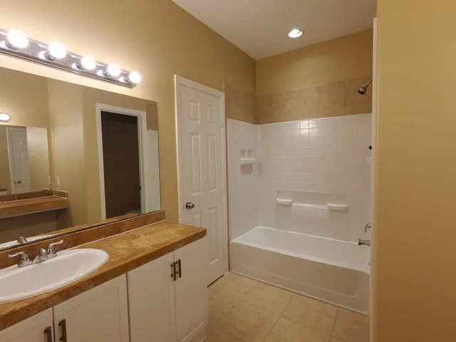 a bathroom with a granite countertop sink a toilet and shower