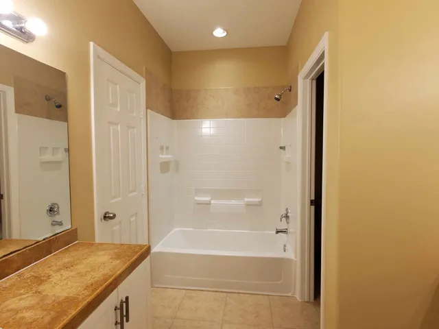 a bathroom with a granite countertop sink and shower